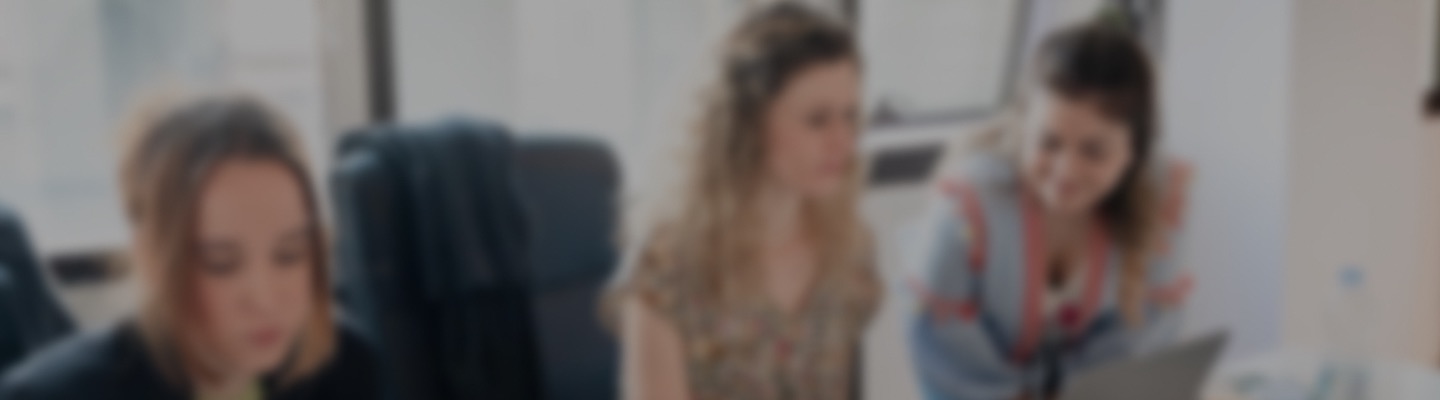 Equipo de trabajo reunido alrededor de un portátil